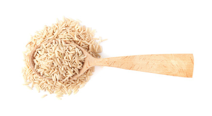 Spoon and uncooked brown rice on white background, top view