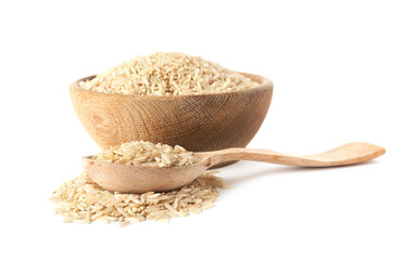 Bowl and spoon with uncooked brown rice on white background