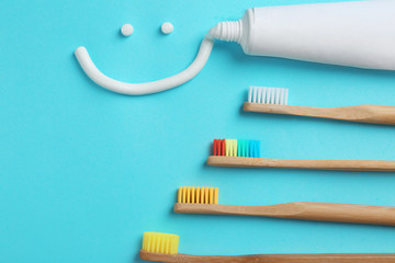 Flat lay composition with smiling face made of toothpaste on color background