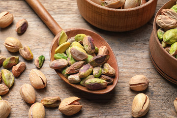 Composition with organic pistachio nuts on wooden table, closeup