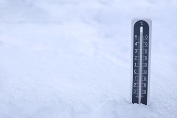 Modern thermometer in snow outdoors. Space for text