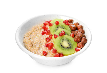 Bowl of quinoa porridge with hazelnuts, kiwi and pomegranate seeds on white background
