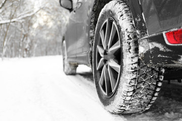 Fototapeta na wymiar Snowy country road with car on winter day, closeup