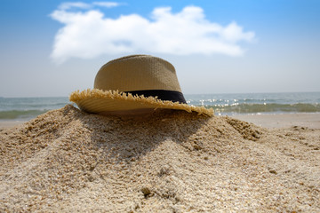 Hat on sand with sea and sky background and summer day