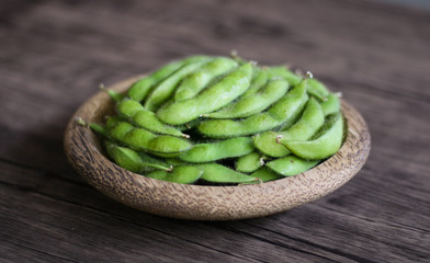 Young soy beans or edamame on wood background.