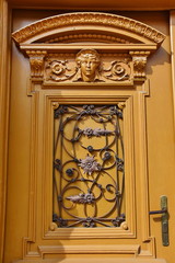 Architectural artistic decorations with wrought iron on old wooden door, in Bistrita