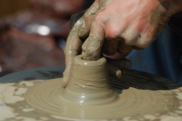  hands of a potter, creating an earthen jar on the circle