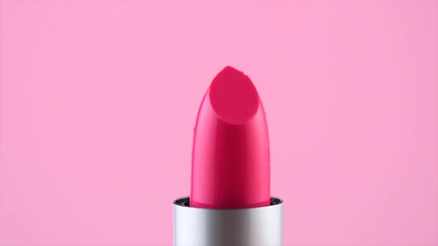 Lipstick. Fashion lipstick closeup rotated over pink or blue background. Professional makeup and beauty. 4K UHD video footage. 3840X2160