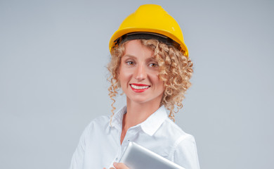 Business woman engineer in yellow safety helmet with tablet