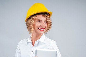 Business woman engineer in yellow safety helmet with tablet