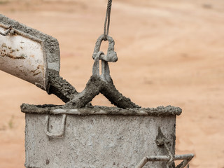 Concrete mixer truck pouring liquid concrete into the tower crane bucket