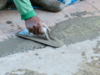 Worker Leveling smooth concrete floors in construction site