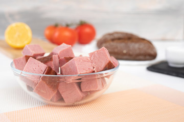 Choped of smoked brisket.Meat products. Lemon, tomatoes and bread on background
