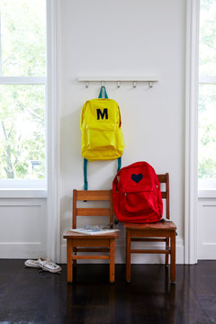 Child's backpacks in room with 2 chairs 