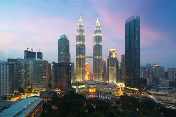 Naklejka premium Gród Kuala Lumpur. Panoramiczny widok na panoramę miasta Kuala Lumpur podczas wschodu słońca oglądanie wieżowców i bliźniaczych wież Petronas w Malezji.