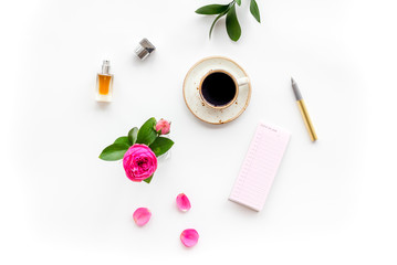 Obraz na płótnie Canvas Feminine desk. Notebook and stationery near pink flowers and coffee on white background top view