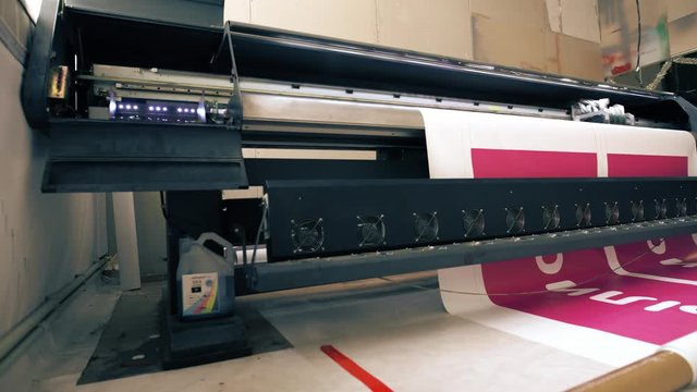 Industrial printer making big colorful banner in workshop 