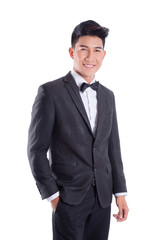 Obraz na płótnie Canvas Portrait of young asian confident man dressed in tuxedo with bow tie isolated on white background