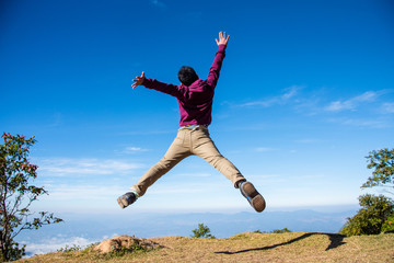 Healthy young man jumping in mid-air with beautiful mountain background.Freedom and success concept.