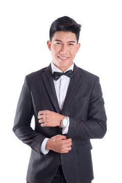 Portrait of young asian confident man dressed in tuxedo with bow tie isolated on white background