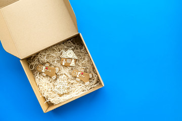 Order goods online concept. Cardboard box with gingerbread cookies on blue background top view space for text