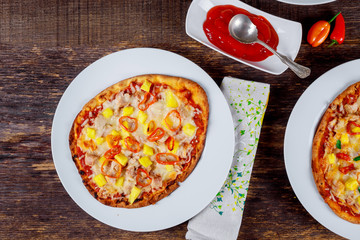 Delicious italian pizzas served on wooden table with ingredients shot from above