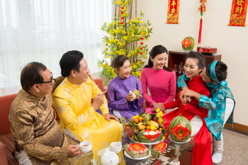 Happy big family enjoying spring festival celebration at home with couplets with best wishes for coming year in background