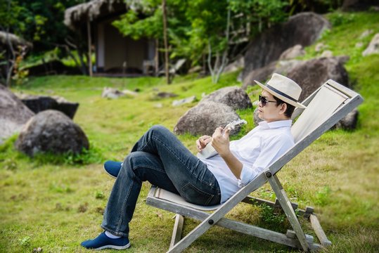 Happy man play guitar in green nature garden - people and music instrument life style in nature concept