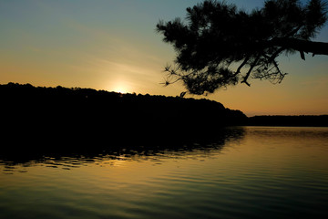 Fototapeta na wymiar View of the water just before the sun peeks over the horizone at dawn at Lake Johnson Park in Raleigh North Carolina.