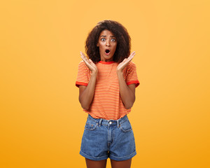Oh no what happened. Worried african american sister with curly hair in trendy striped t-shirt and...
