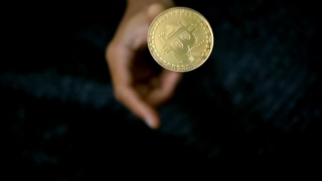 slowmotion shot tossing bitcoin to flip on heads or tails