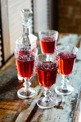 sweet berries alcoholic cordial in the decanter with a glass