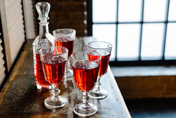 sweet berries alcoholic cordial in the decanter with a glass