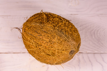 One whole coconut on a wooden table. Top view