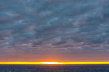 Puffy clouds and sunset over the ocean