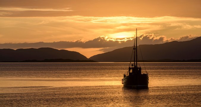 Sunset over the sea and wooden boat, Crinan, Scotland, Great Britain