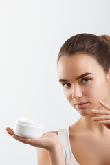 Fototapeta na wymiar Beauty Concept. woman holds a cream in her hand and spreads it on her face to moisturize her skin and wrinkle from impurities. body care, skincare.Taking good care of her skin
