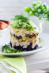 Chicken and prune salad garnished with cucumber and greens, selective focus