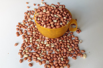 Fresh peanuts on a white table closeup. Concept of vegan food or healthy eating.