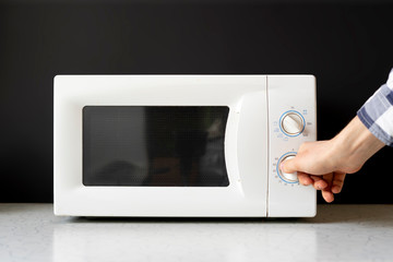 Fototapeta premium closeup photo of man use microvave oven to heat the food f