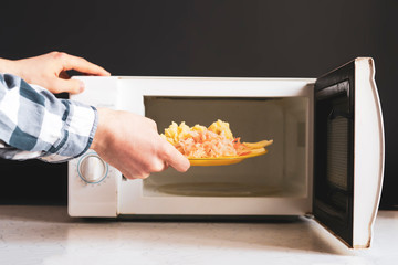 closeup photo of man use  microvave oven to heat the food f