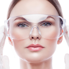 Close-up Beauty face of model girl beautician wearing cosmetology professional salon or clinic medical equipment glasses and gloves