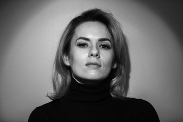 Dramatic black and white portrait of a beautiful woman on a dark background