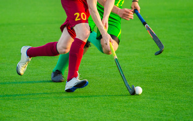 Two man battle for control of ball during field hockey game - obrazy, fototapety, plakaty