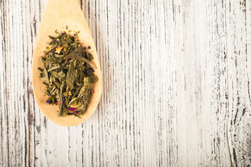 Organic natural green tea on a wooden spoon close-up. Brewed tea on a spoon on the background of...