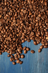 Pile of coffee beans on blue wood