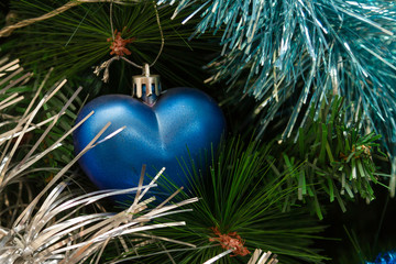 Fototapeta na wymiar Christmas toy in the form of a heart on a Christmas tree