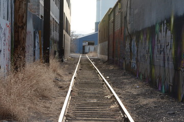 Railway in city with a graffiti tagger, spray painting, tagging, marking