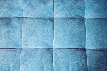 Close-up comfortable blue soft back of the sofa with curly stitching. Modern design