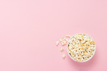 Bowl with popcorn on a pink background. Flat lay, top view